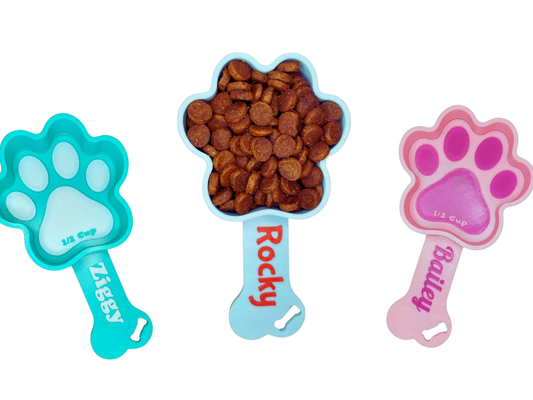 Three paw-shaped dog personalized scoops with names 'Ziggy', 'Rocky', and 'Bella' on a white background - PawsFRVR